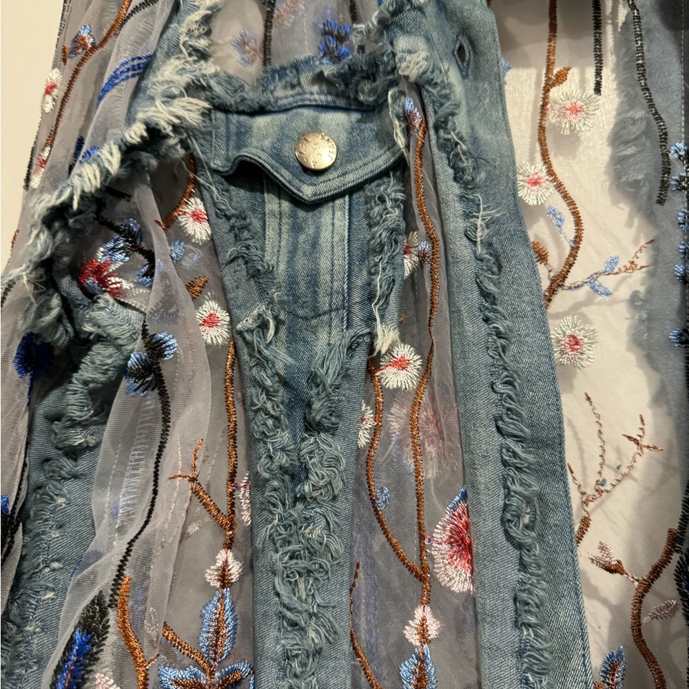 Deconstructed denim jacket with embroidery.